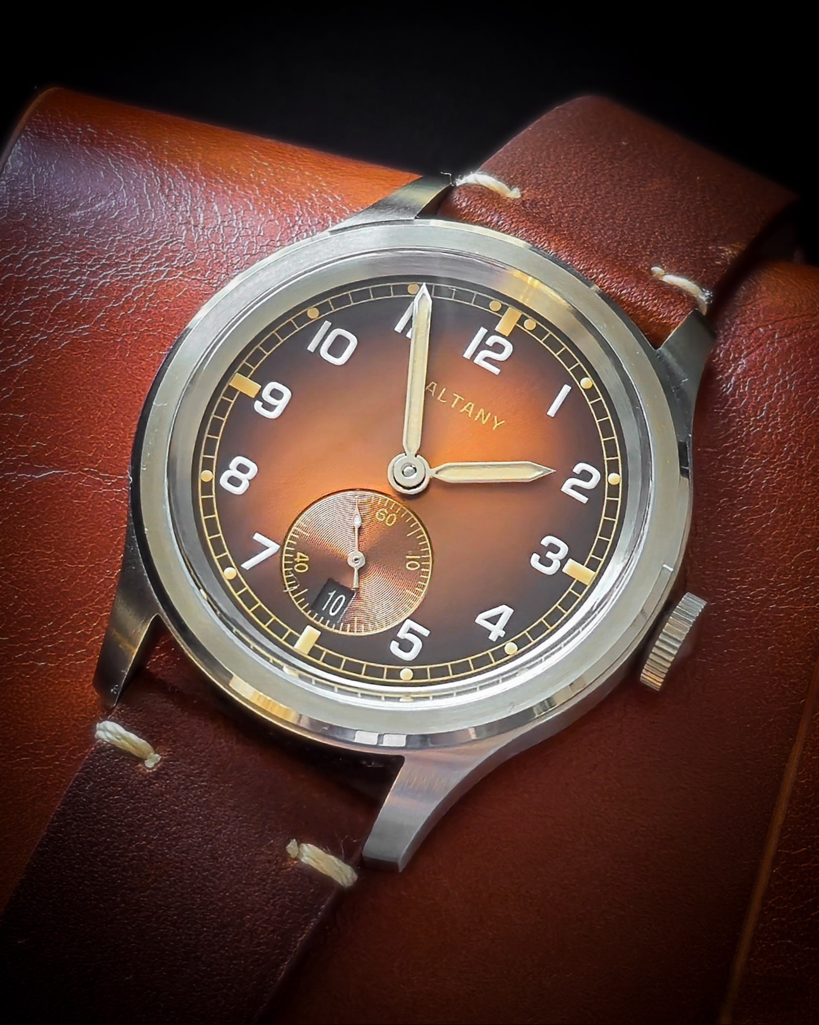 Baltany Dirty Dozen vintage watch close-up with visible dial and strap, placed on a brown leather watch-roll.